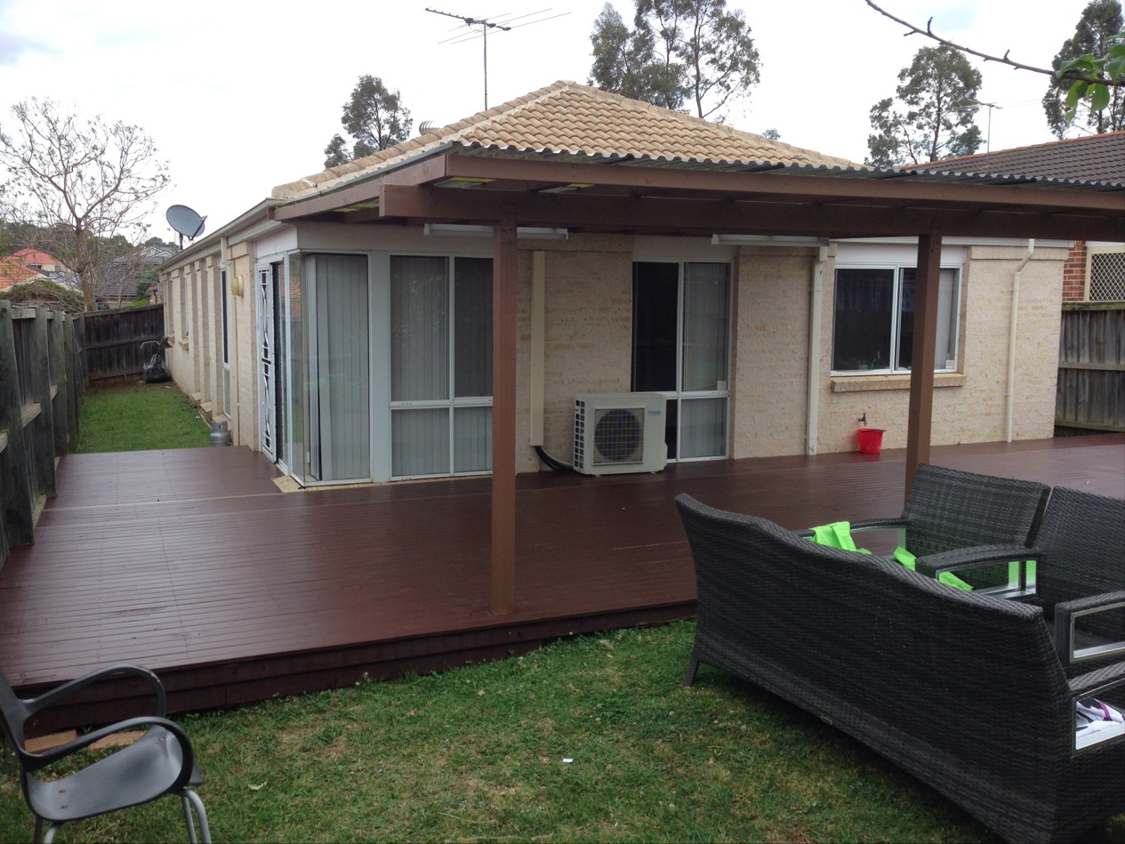Rear deck and pergola extension on a brick house with outdoor furniture